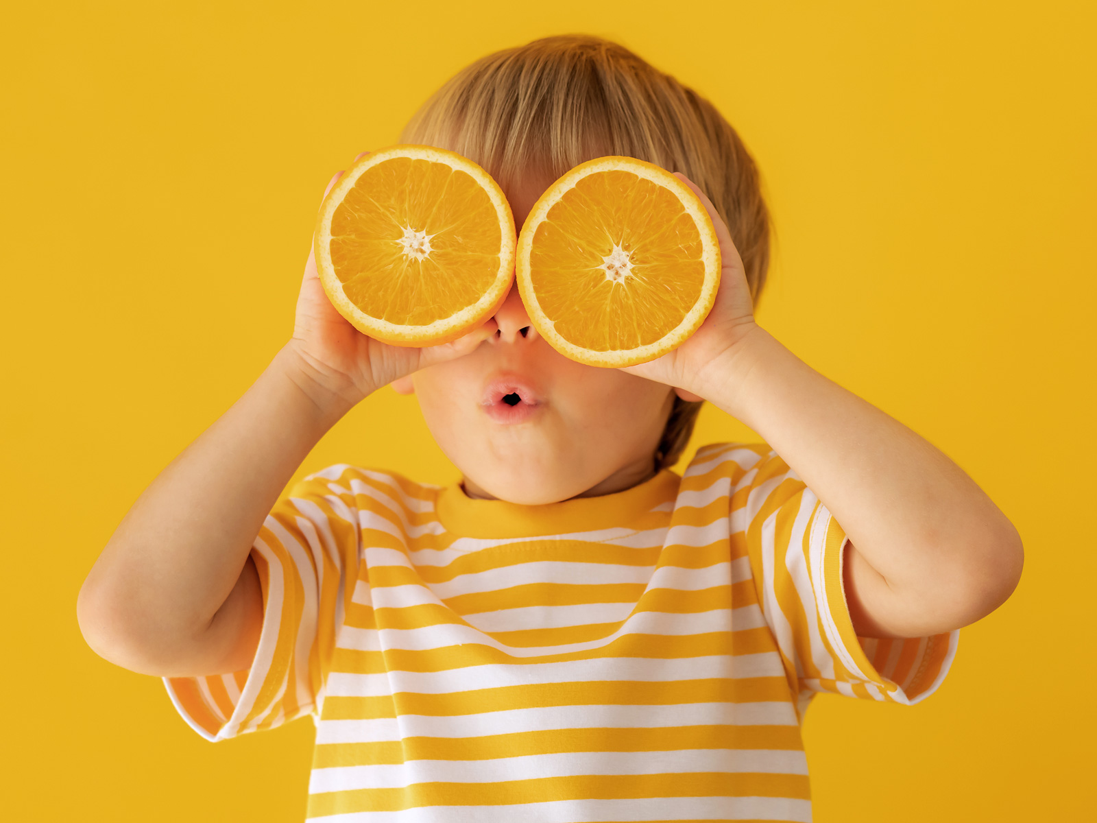 Wir kochen Schul- und Kita-Essen – Menü Niederwiesa GmbH & Co KG Junge mit Orange